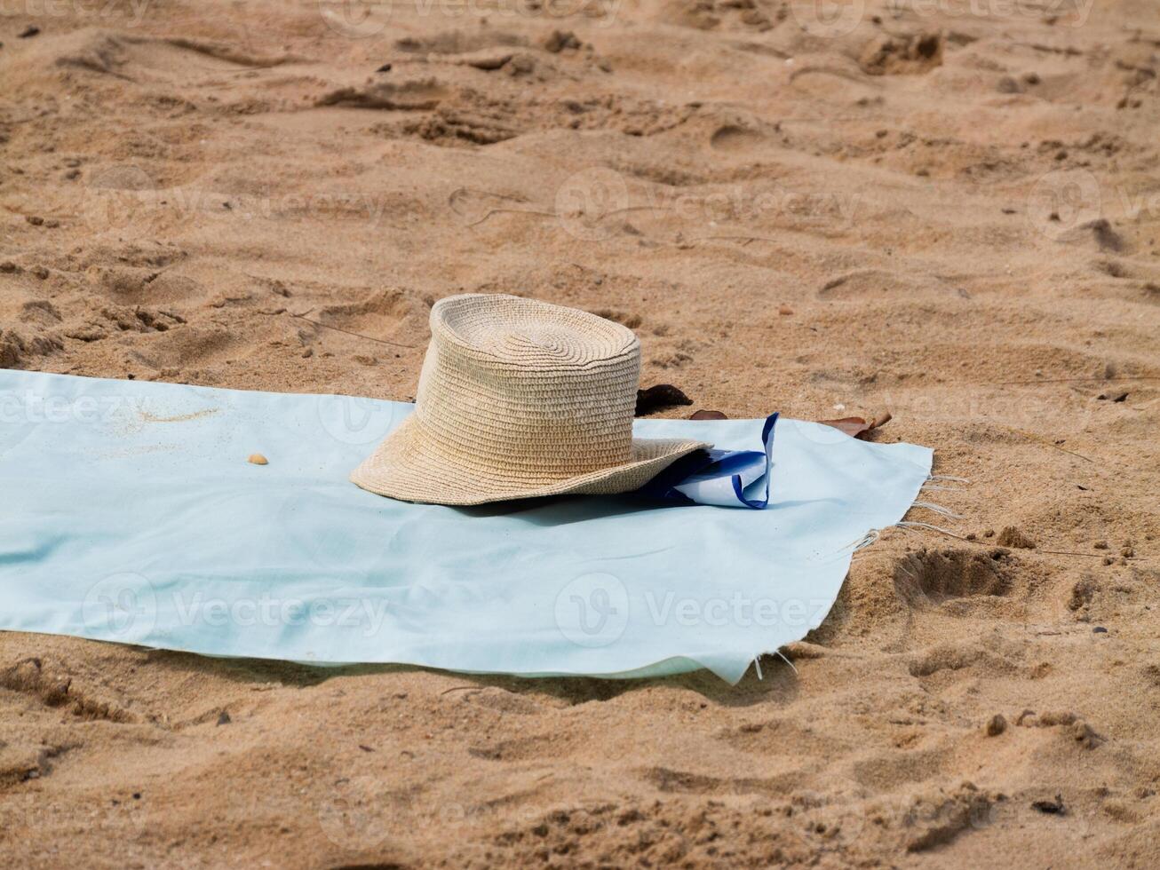 Beach day essentials sun hat towel sandy shoreline outdoor scene relaxed atmosphere photo
