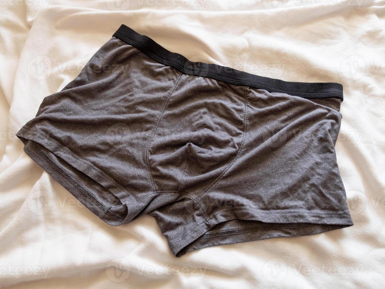 Men's grey boxer briefs bed casual clothing indoor setting top view everyday comfort photo