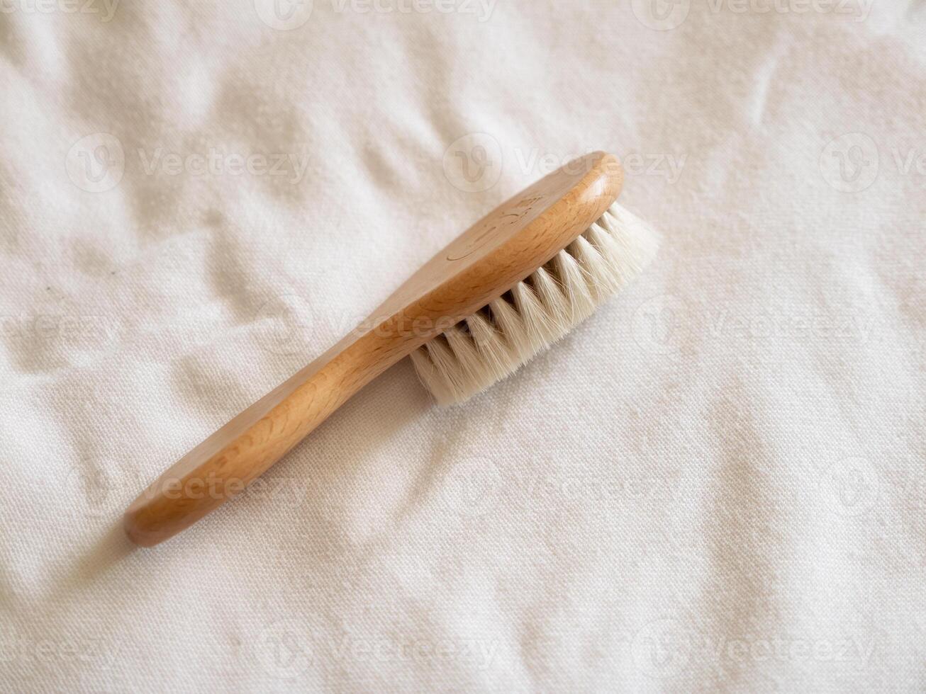 Handcrafted wooden brush soft fabric surface studio setting product close-up view natural concept photo