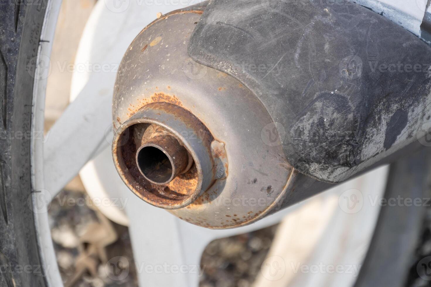 Close-up of a corroded motorcycle exhaust pipe in rusty condition in a mechanical environment photo