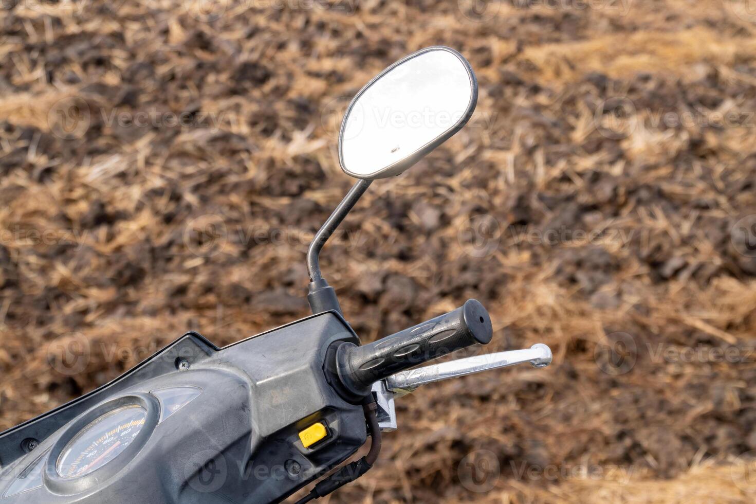 Motorcycle handlebar close-up rural field natural environment ground level detail focus photo