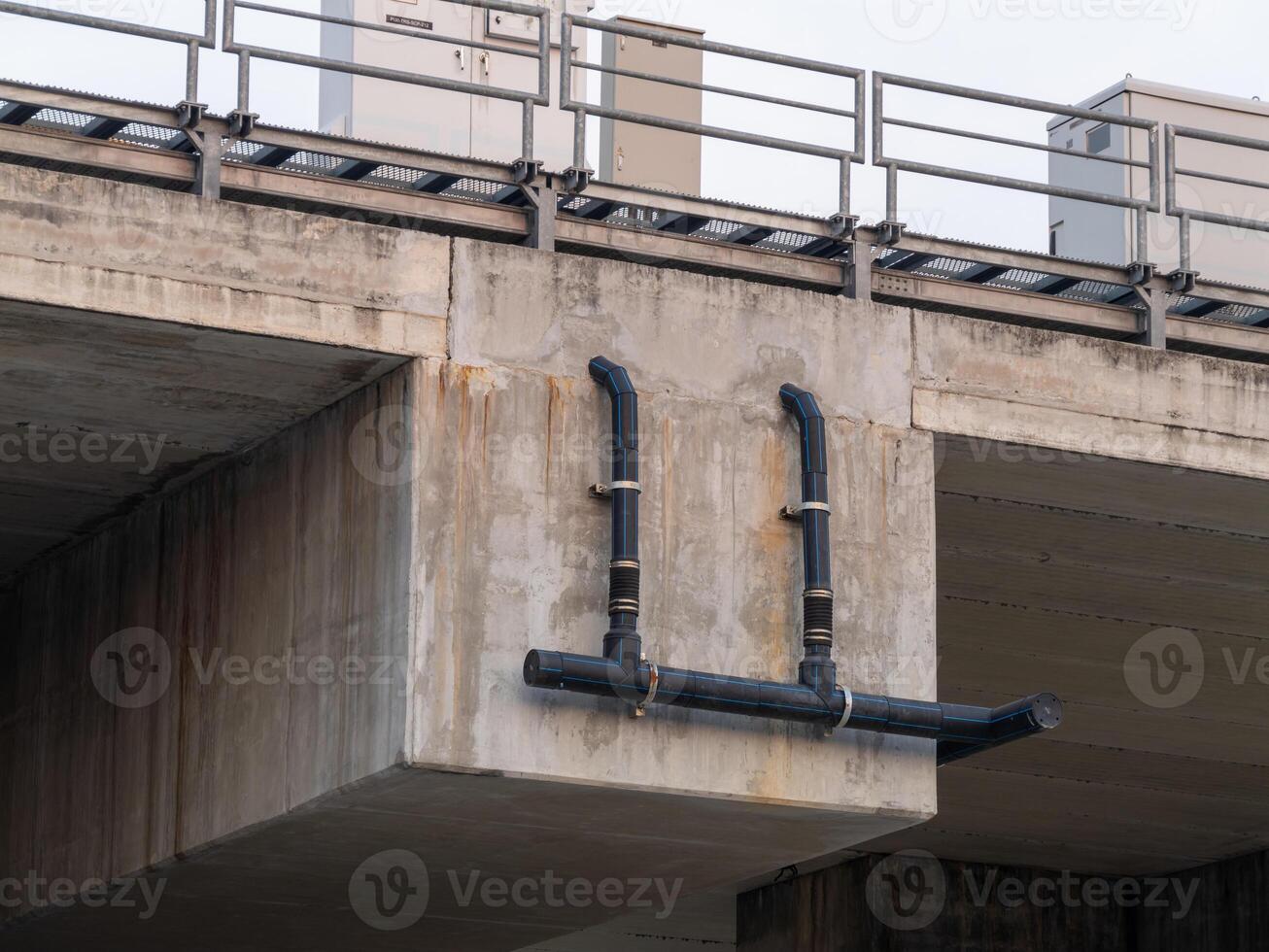 Urban infrastructure elevated industrial pipe installation over concrete bridge photo