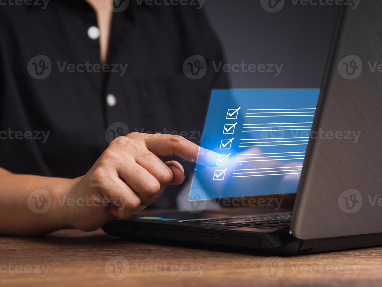 Businessman touching a checkmark symbol on a document management system or DMS on a virtual screen photo