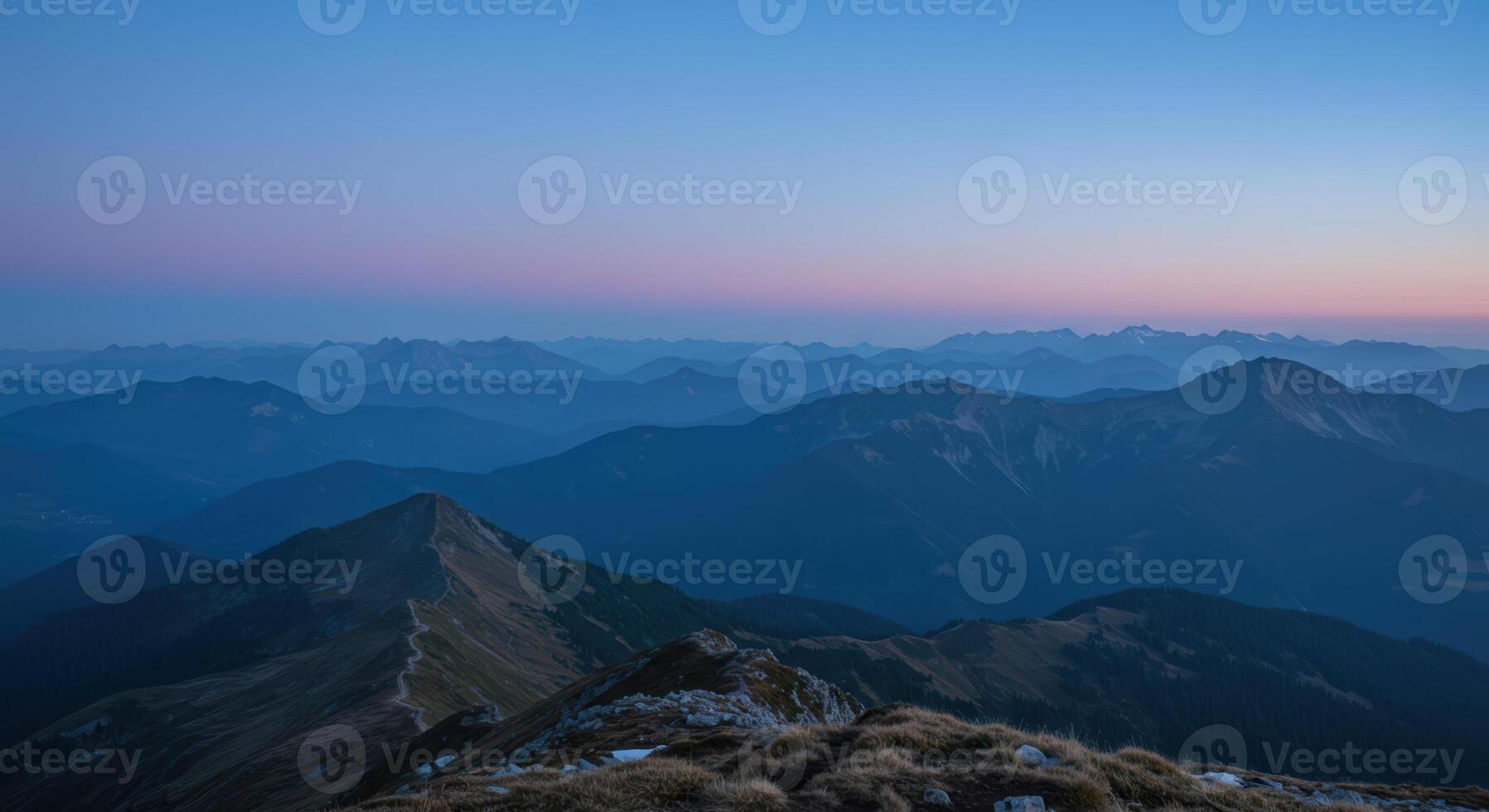 Layered mountain peaks stretch to the horizon during twilight offering a panoramic view of nature photo