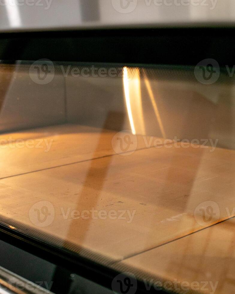 Golden rays dance on empty oven shelves, echoing a bakers anticipation, during Sourdough September and World Baking Day photo