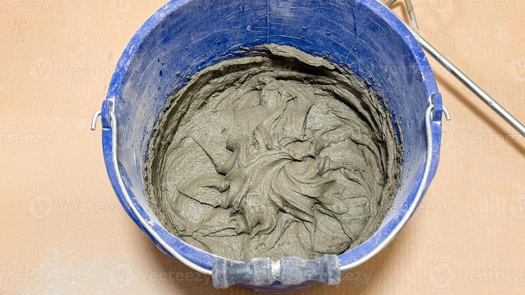 Whirling cement in a cobalt bucket spins tales of artisan craftsmanship, echoing Labor Day and World Creativity Day photo