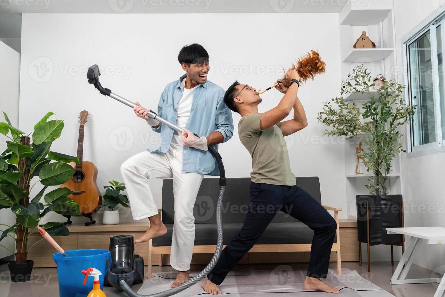 Energetic Cleaning Duo. Two friends having fun while cleaning their living room. photo