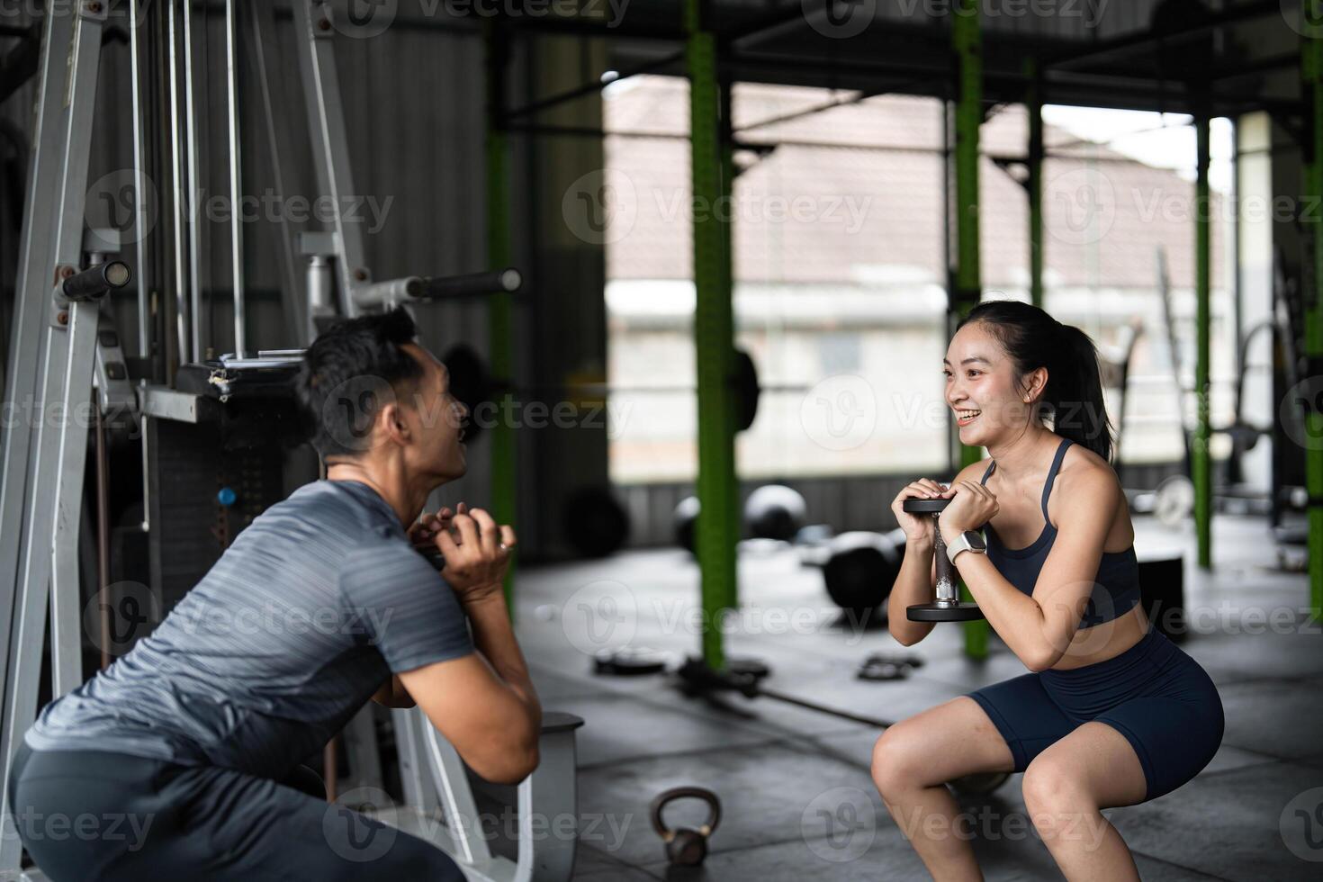 Strength Training and Personal Coaching. A trainer guiding a woman through squats with weights in a gym. photo