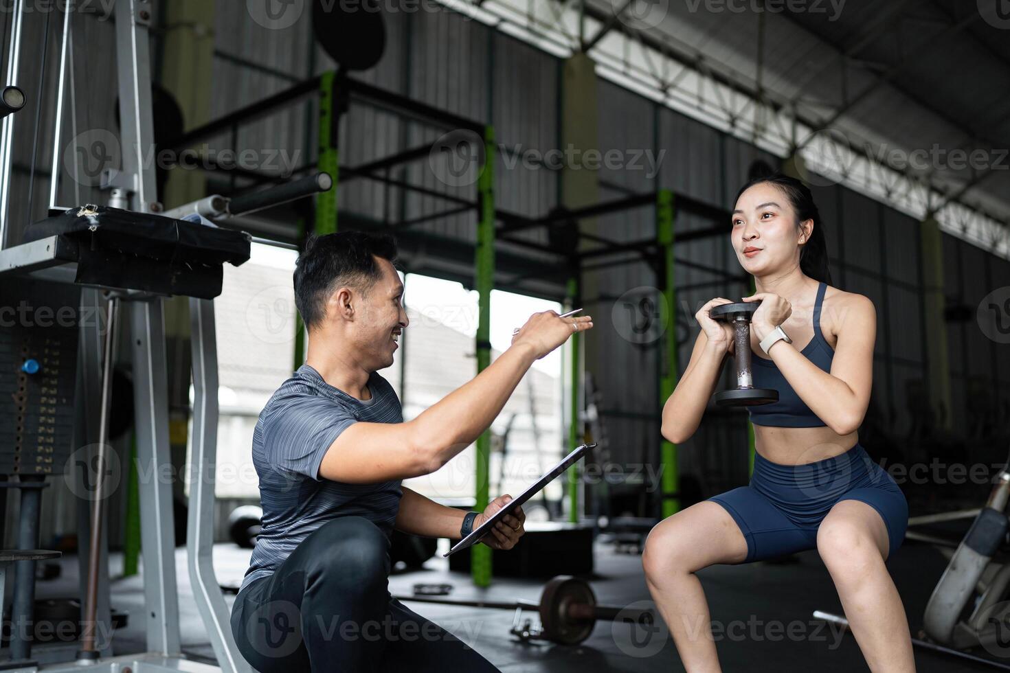 Fitness Coaching and Support. Personal trainer encouraging a young woman during her workout. photo