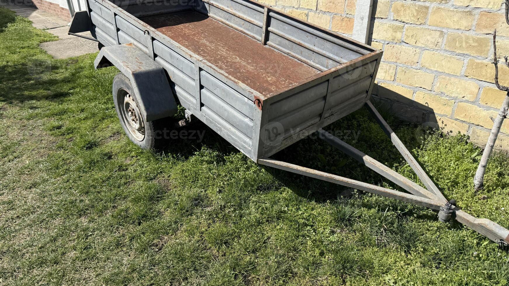 Rustic trailer basks in sunshine, whispering tales of harvest festivals and countryside escapades, embodying rural nostalgia and simplicity photo