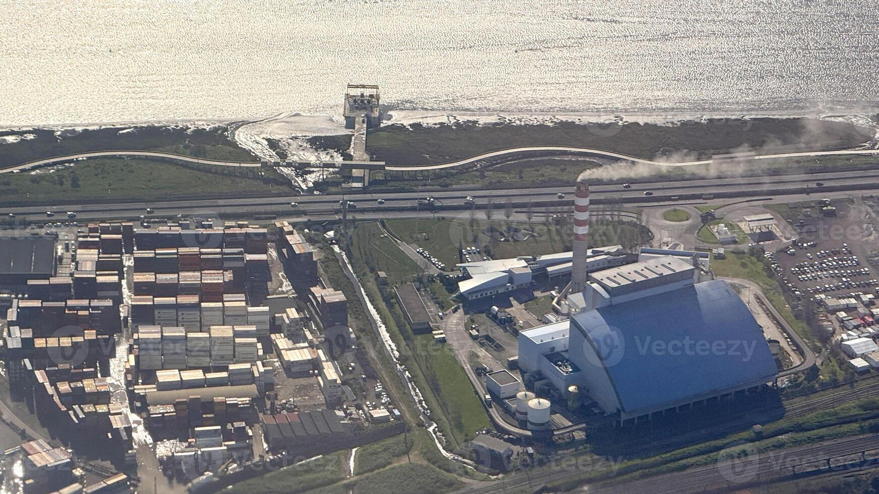 Coastal power plant whispers secrets to busy shipping containers, industrial symphony on World Maritime Day, sustainable energy tales photo