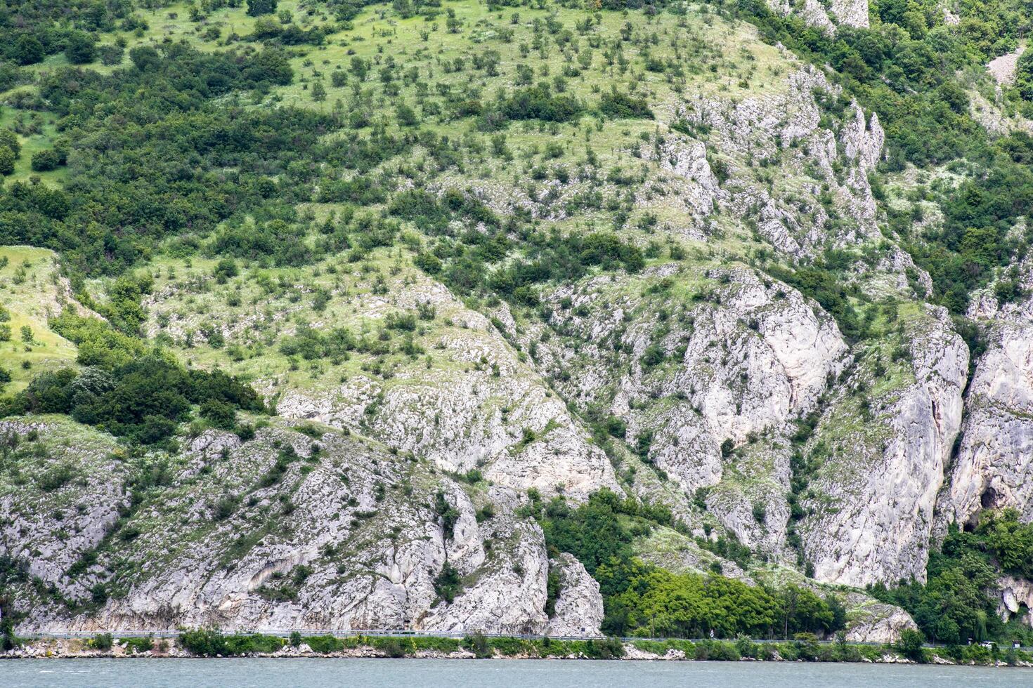 Rocky emerald hills cascade into serene waters, ideal for Earth Day reflections or Walpurgis Night nature reverie photo