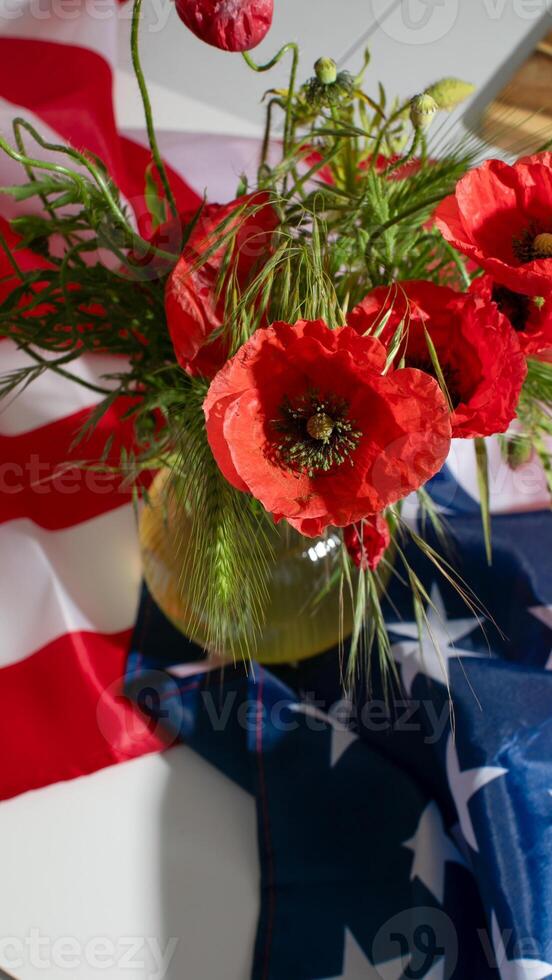Bustling crimson poppies dance with tangled greenery against a backdrop of stars and stripes, reflecting Memorial Day introspection photo