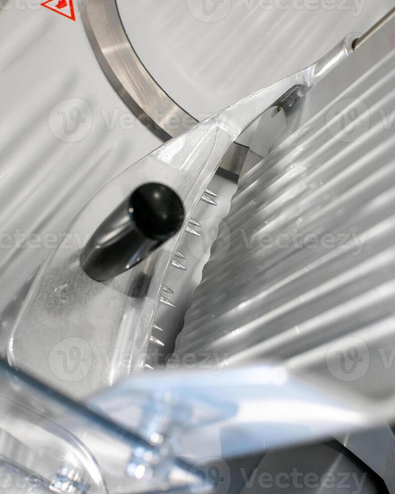 Sleek metal slicer gleams under fluorescent light, embodying industrial precision, a nod to International Mechanical Engineers Day photo