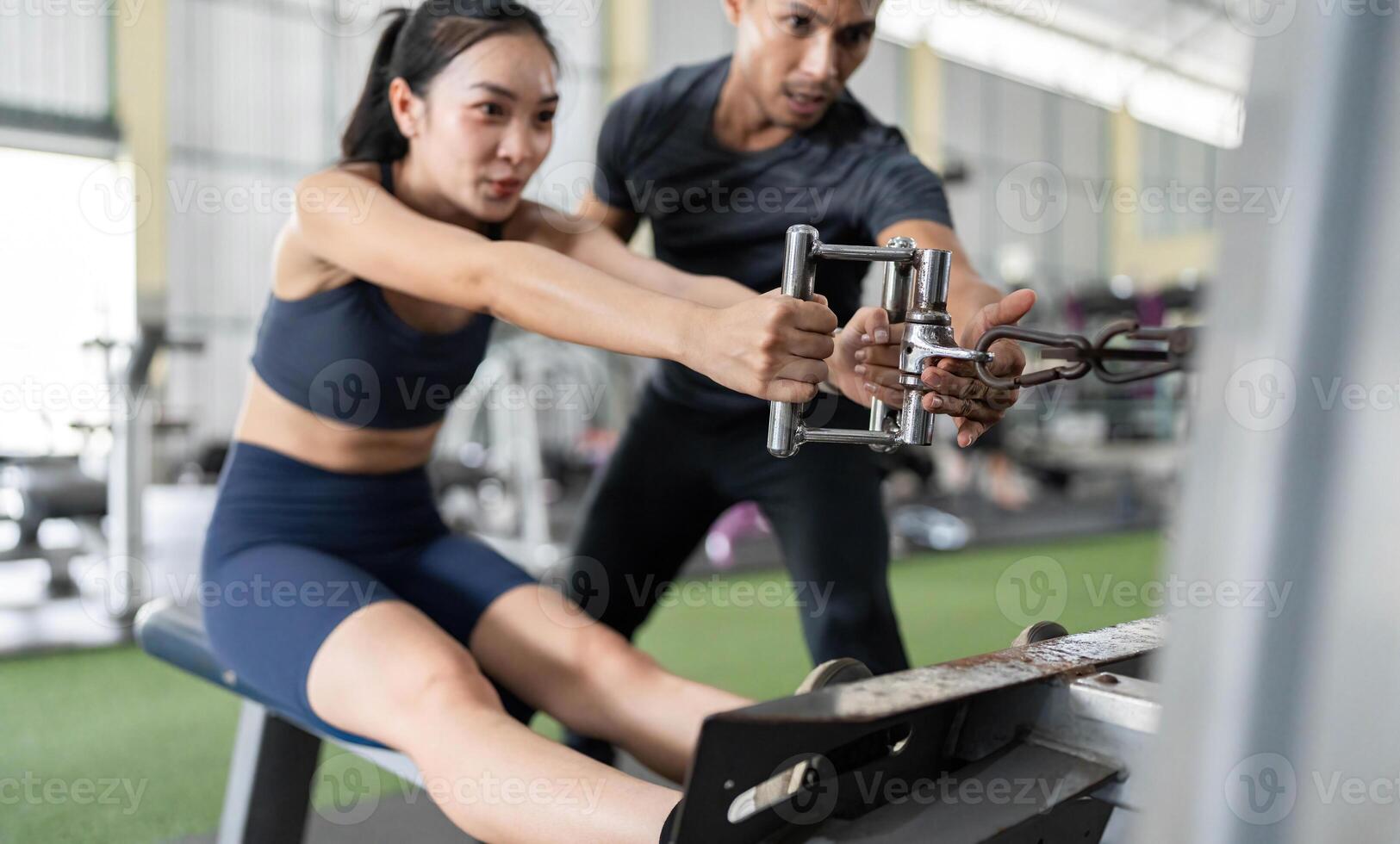 Fitness Trainer Assisting Client with Rowing Machine Workout photo