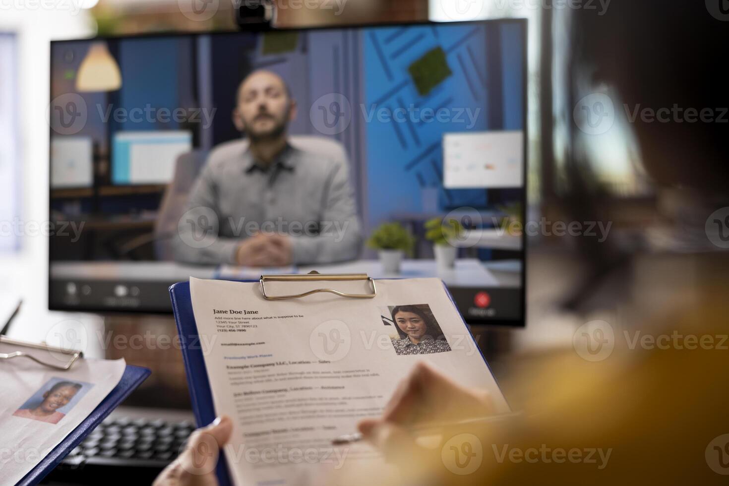 Closeup of cv resume of female job candidate being help by a person during a meeting with remote manager. Selective focus of a curriculum vitae in the hands of an individual attending a call. photo