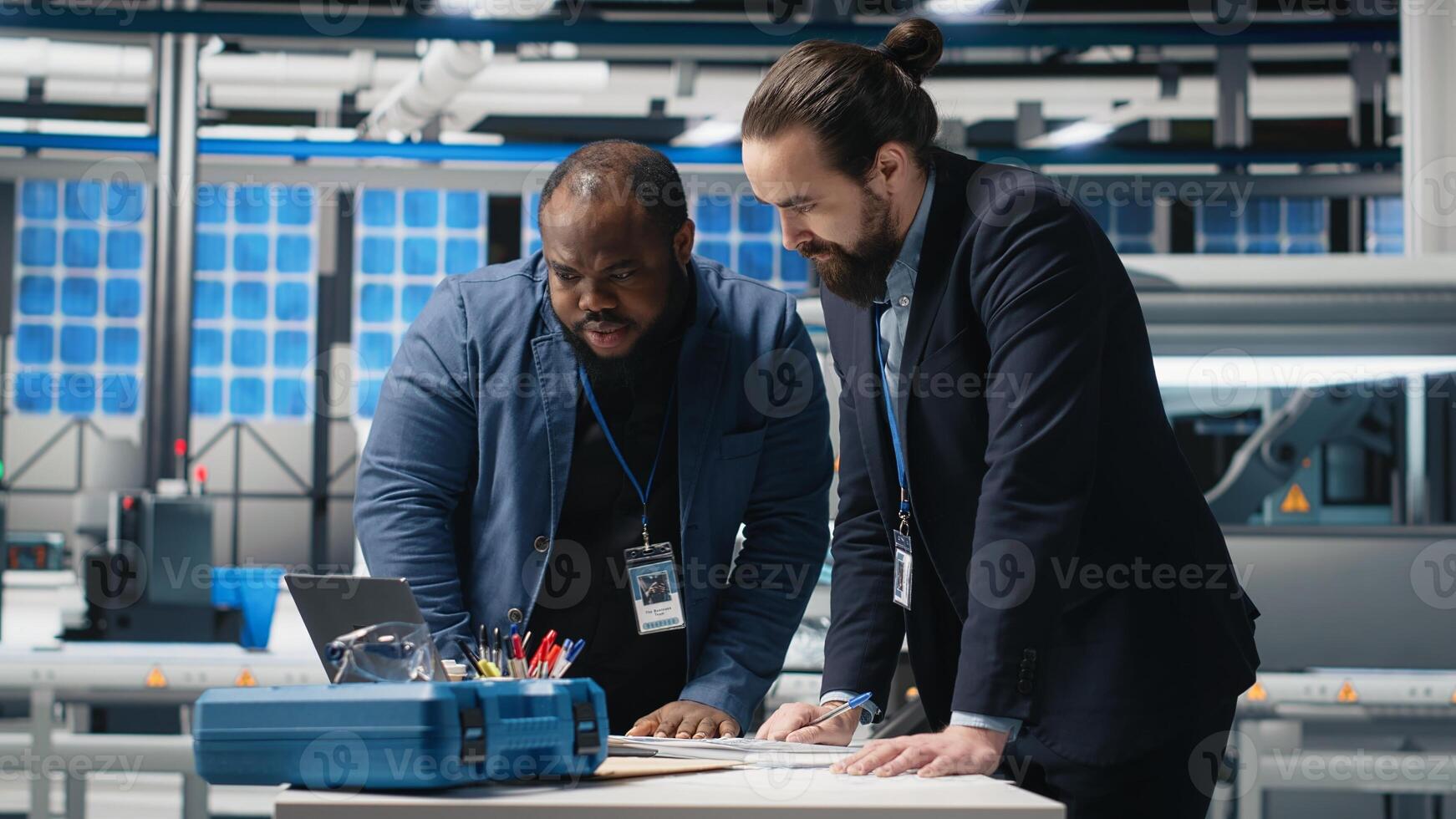 Multiethnic engineers industrial coworkers doing teamwork on production line for solar panels, combining technical insight and teamwork to drive forward clean energy infrastructure. Camera B. photo