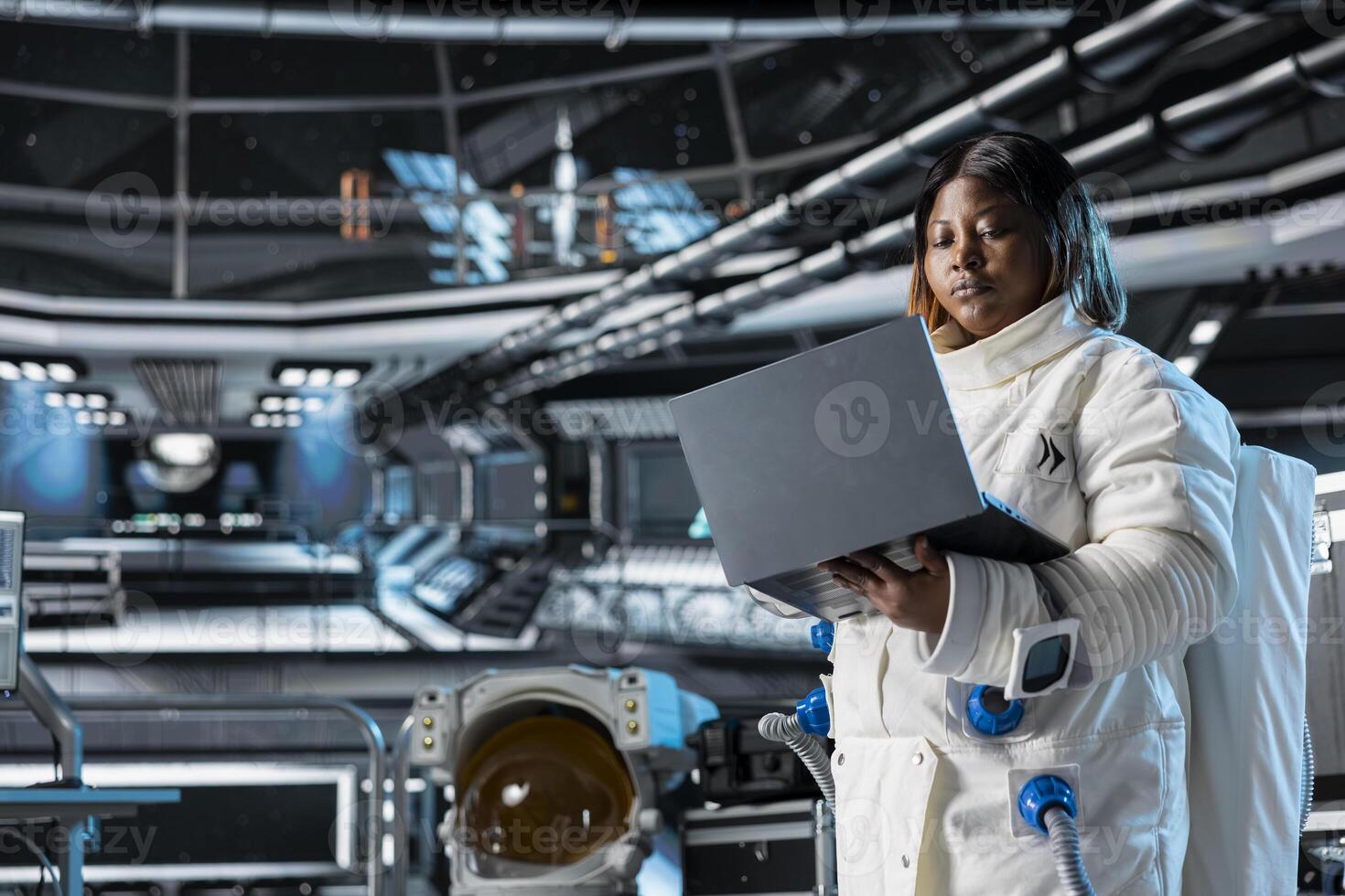 Astronaut using laptop to confirm suit integrity, monitoring life support systems. Orbital station crew member testing gear during routine equipment check using notebook, conducting safety checks photo