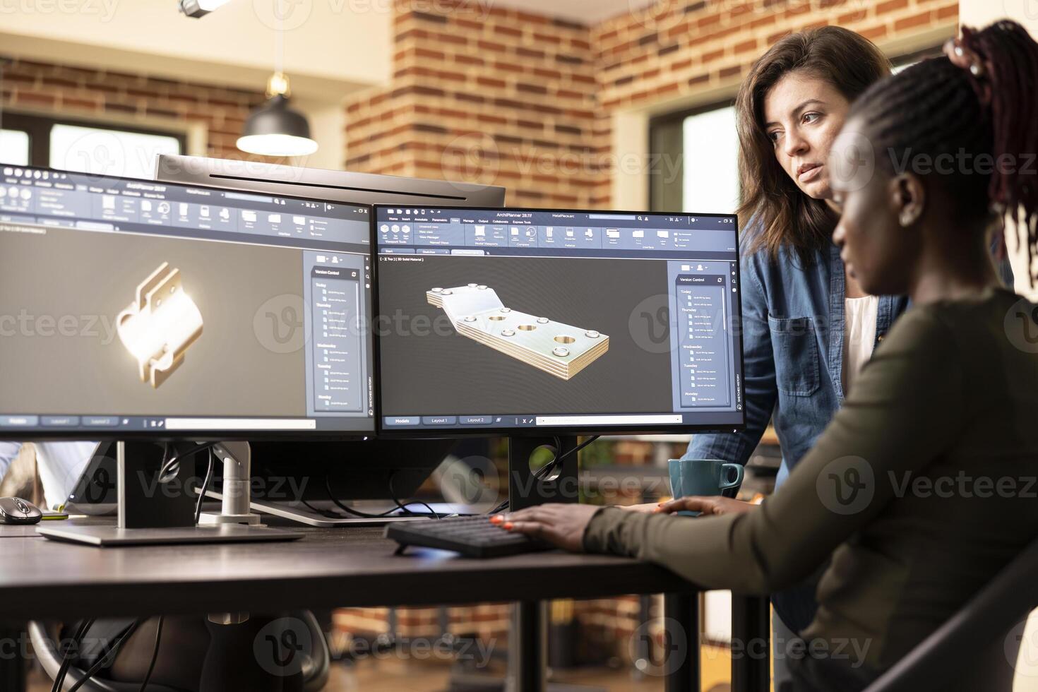 Black and caucasian female engineers collaborating at desk, trying to develop the geometry of 3d design for a construction company. African american developer using cad software on a multi monitor. photo