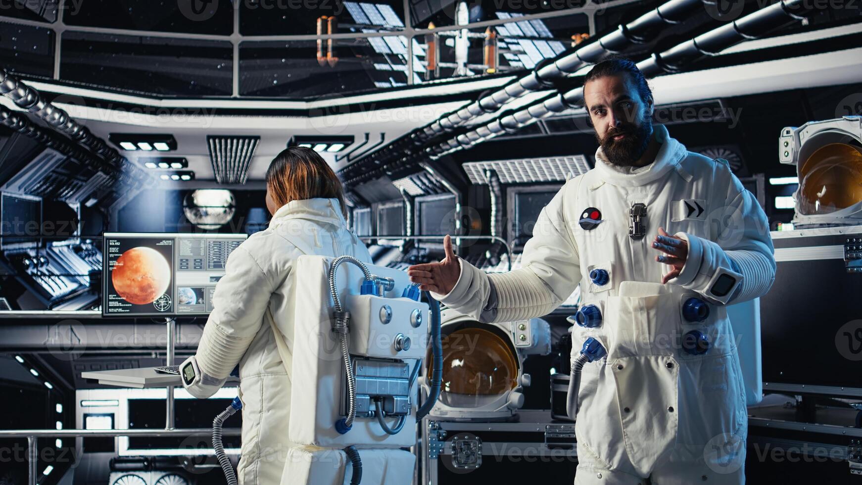 Astronaut waves hand, communicating with command center during videocall to share recent orbit discoveries. Cosmonaut salutes Earth team, provides scientific findings from spacecraft photo