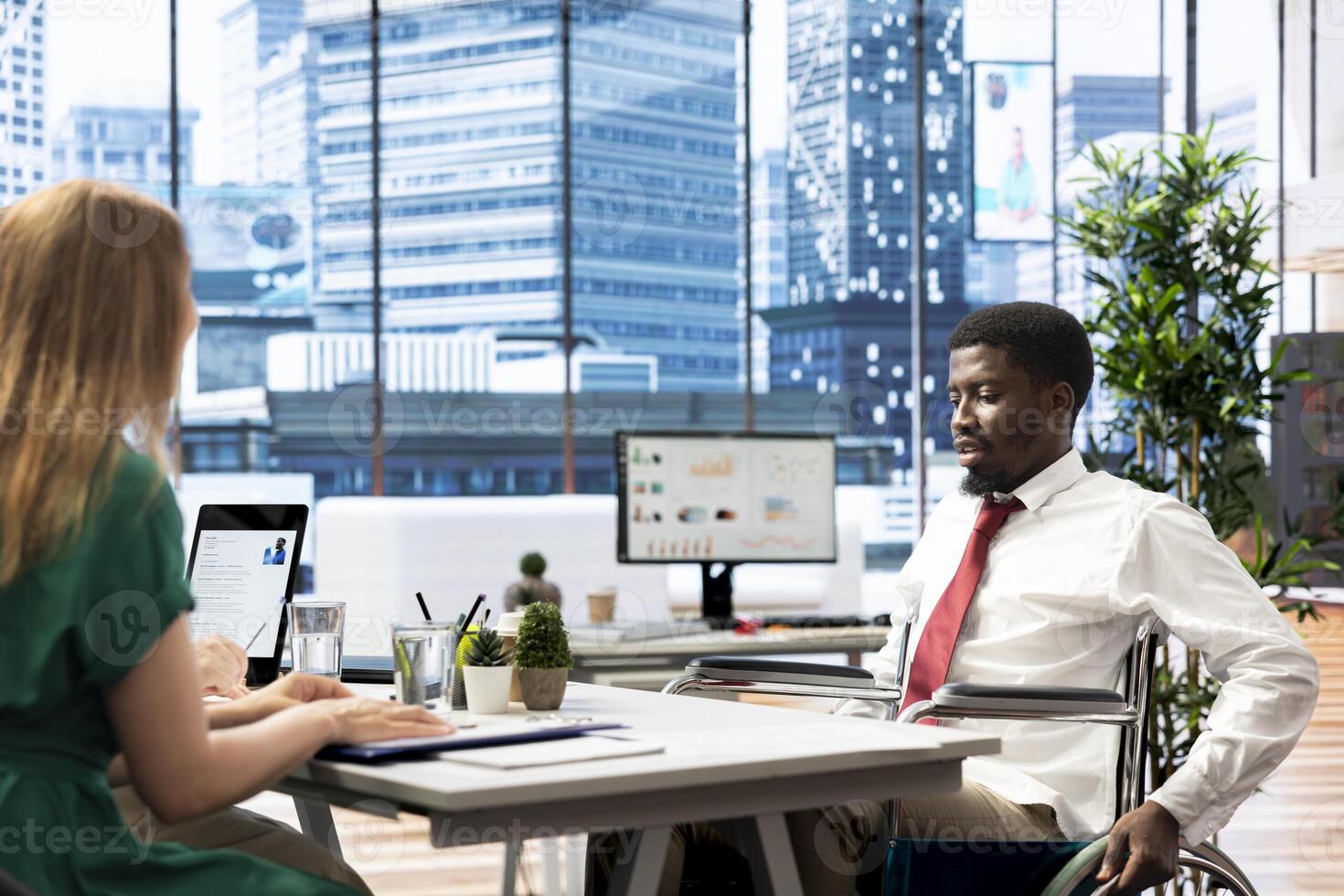 HR worker implementing diversity and inclusivity recruitment strategy for company, hiring person with paraplegia. Recruiter reaching agreement with african american wheelchair user photo