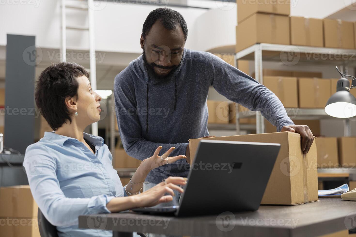 Diverse workers managing the order logistics for small business shipment operations, ensuring express delivery for a local brand. Working on product handling in the supply room. E commerce. photo