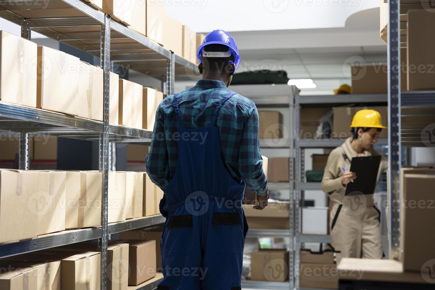 African american man staff managing order shipment with boxes and products for e commerce distribution. Warehouse operations with transportation and logistics, inventory management. photo