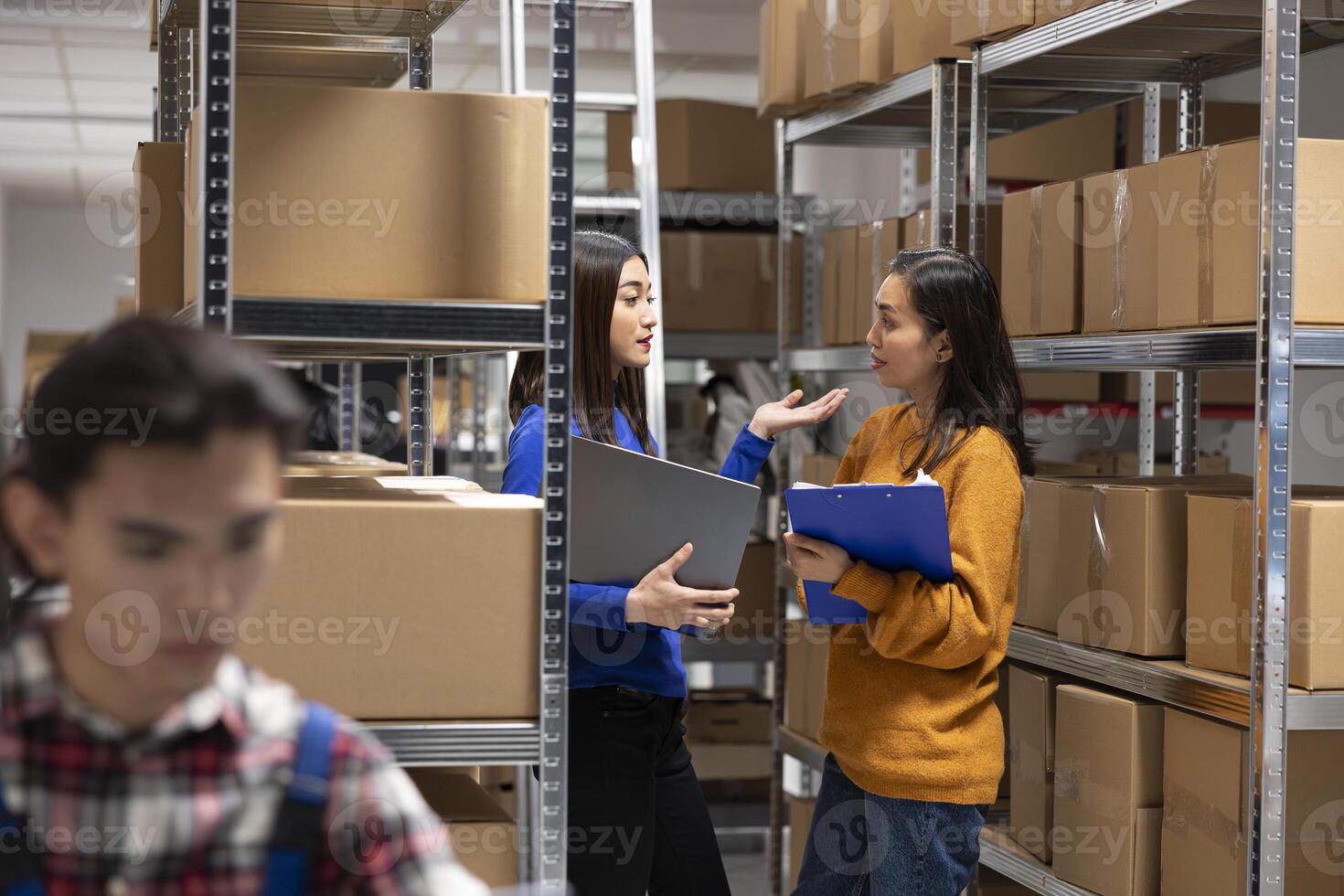 Asian staff members checking parcels at a startup fulfillment center. Local delivery and in house logistics supported by organized storage, taped boxes and efficient inventory management. photo