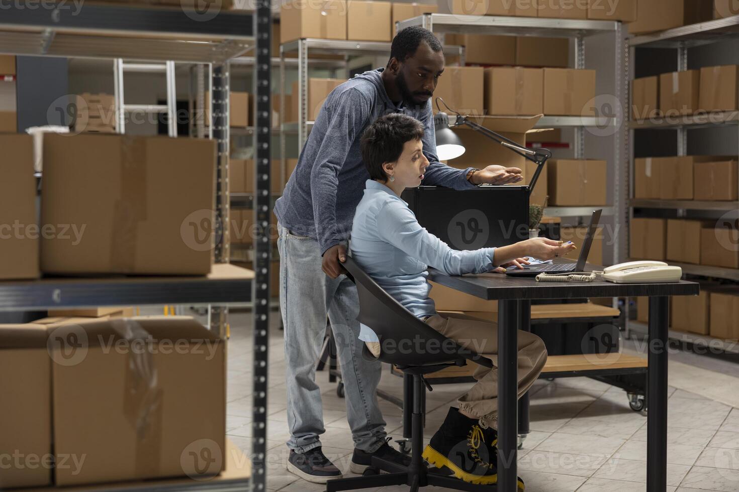 Multiethnic staff uses distribution hub logistics for order processing, coordinating logistics in a small warehouse. Solving business operations and tasks of a local delivery company. photo