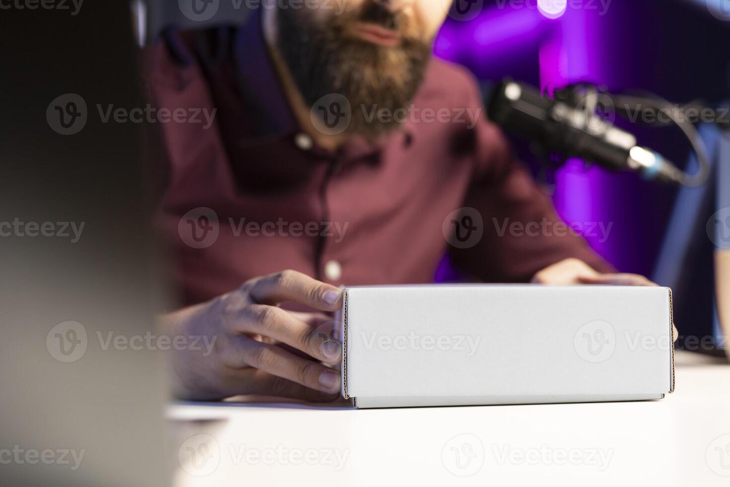 Close up shot of packaged product ready to be unboxed by tech guru for for technology vlog. Focus on box presented by influencer urging fans to buy sponsoring partner merchandise photo