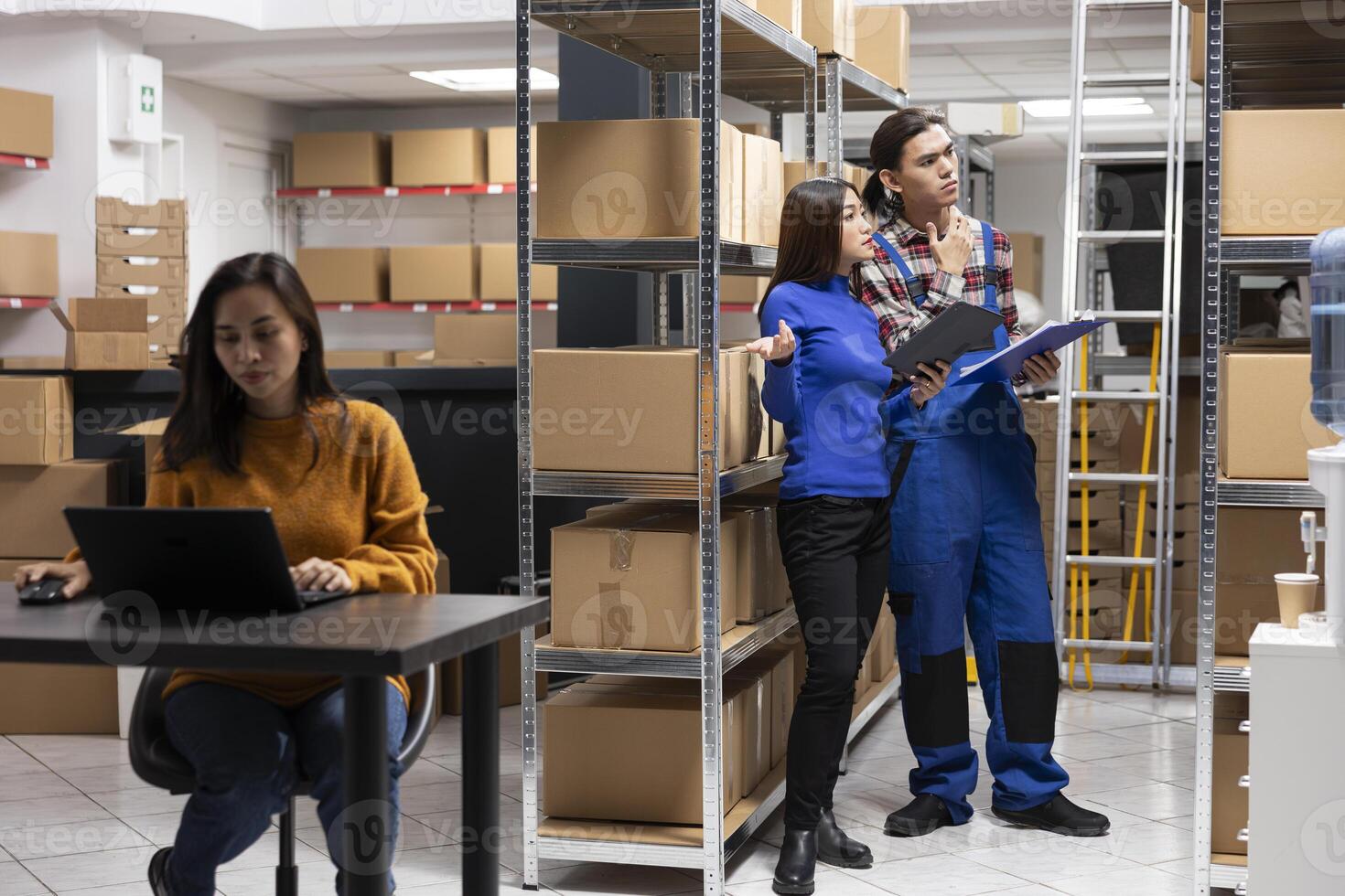 Asian team of workers in a depot checking the packages for shipment logistics, overseeing express delivery for orders. Staff focusing on growing the local brand small business. photo