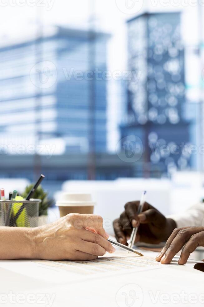HR specialist negotiating job offers and salary packages with candidate after successful discussion. Close up of manager in workplace analyzing person resume, cover letter and background information photo