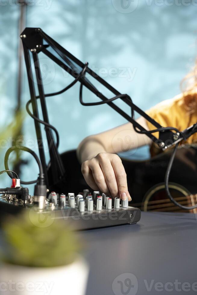 Artist filming DJ mixing tutorial, showing examples of sampling on sound controller to audience. Close up of viral internet star showing modern musical equipment to subscribers in home studio photo