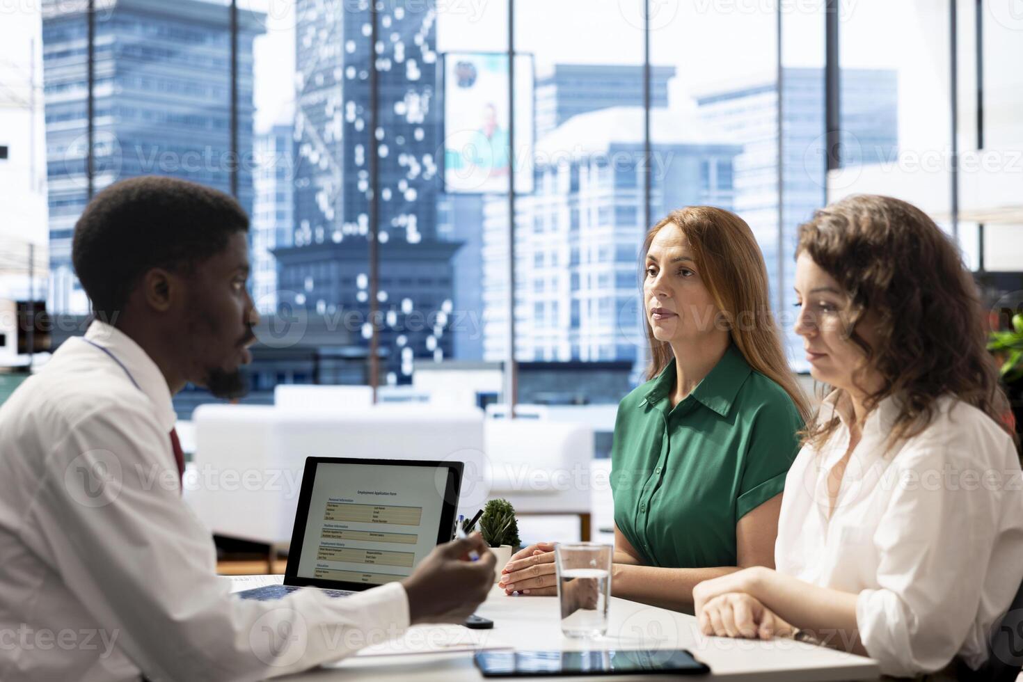 HR professionals at office desk determining if candidate possesses skills and experience needed to fulfil role. Headhunters interviewing intern, evaluating if qualifications align with company photo