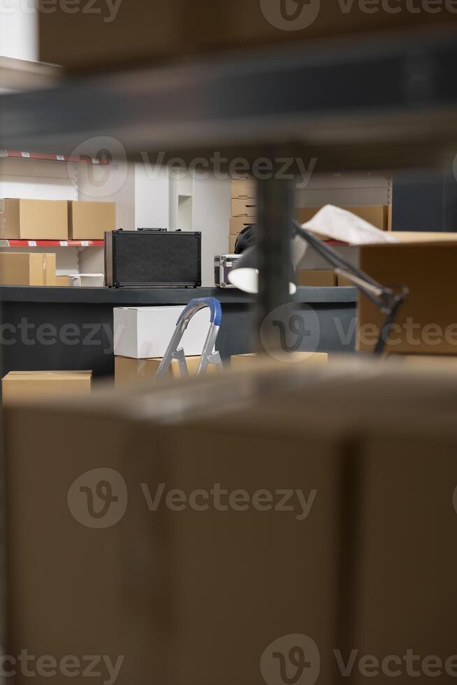 Empty storage room with taped boxes and products for a local brand retail business, ensuring the structure of inventory room and shipping system for custom orders and express delivery. photo