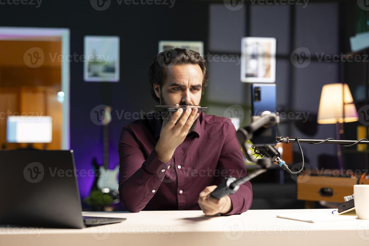 Media star presenting mobile phone from brand sponsoring , urging subscribers to purchase it. Tech guru does influencer marketing by advertising smartphone to audience photo