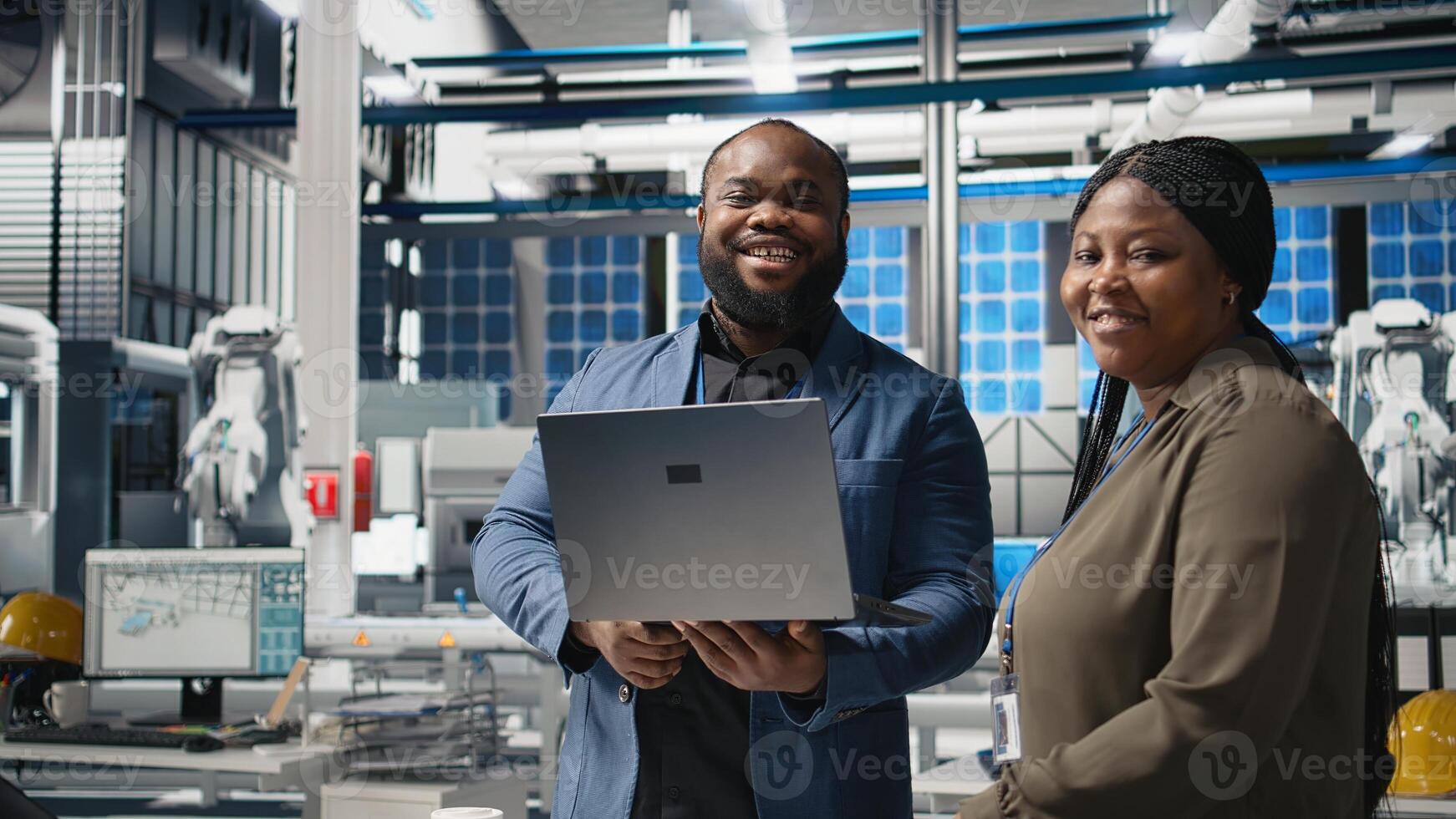 Black factory inspectors engaging in a briefing over the manufacturing process, reviewing production line and metrics on files. Supporting renewable energy improvement. Camera A. photo
