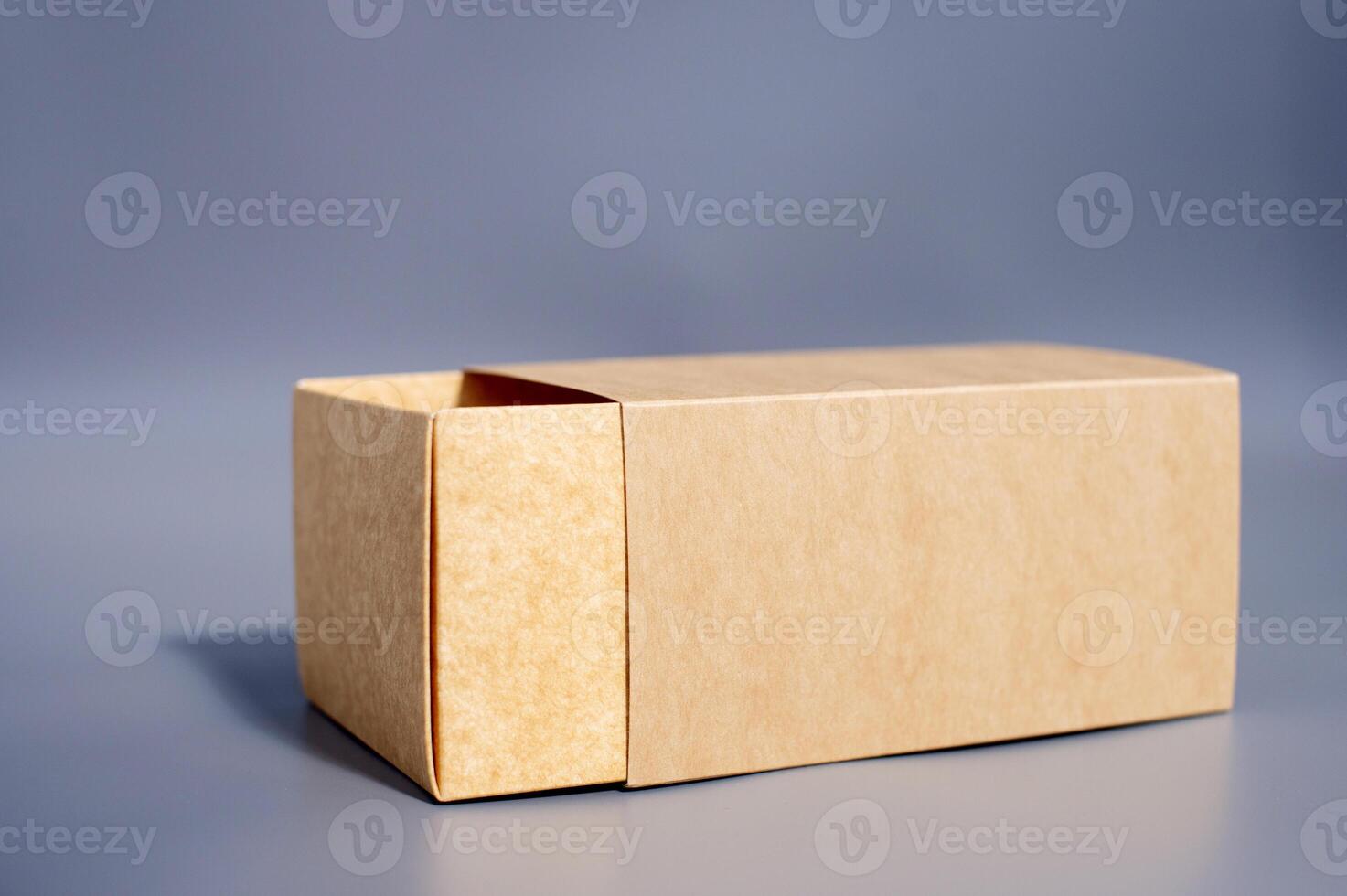 Simple open brown cardboard box on gray surface photo