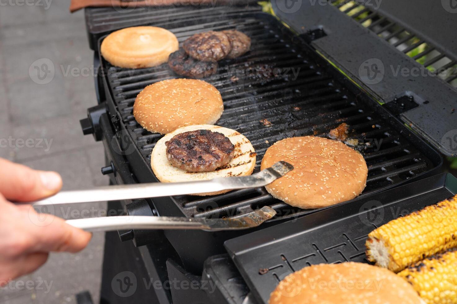 Grilling burgers and corn on outdoor barbecue grill photo