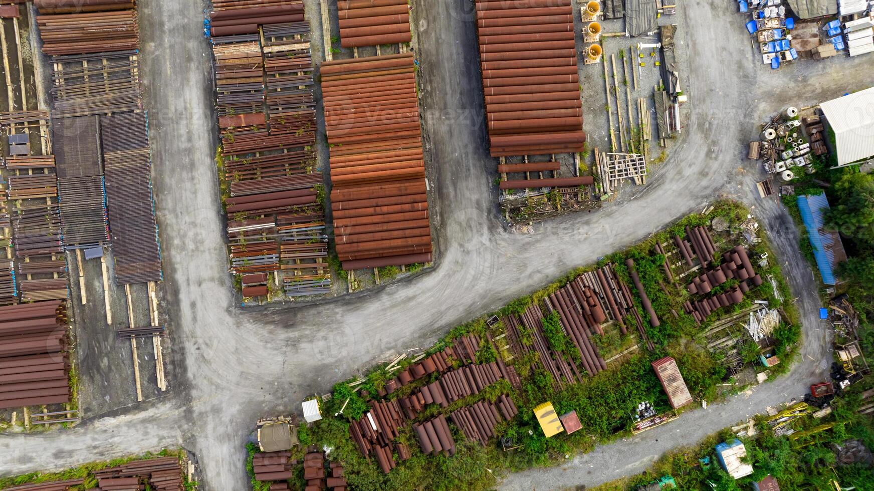 Aerial view of industrial steel pipe yard. Rusted and new construction materials. Infrastructure supply, recycling potential, and urban storage logistics. Sustainable infrastructure management. photo