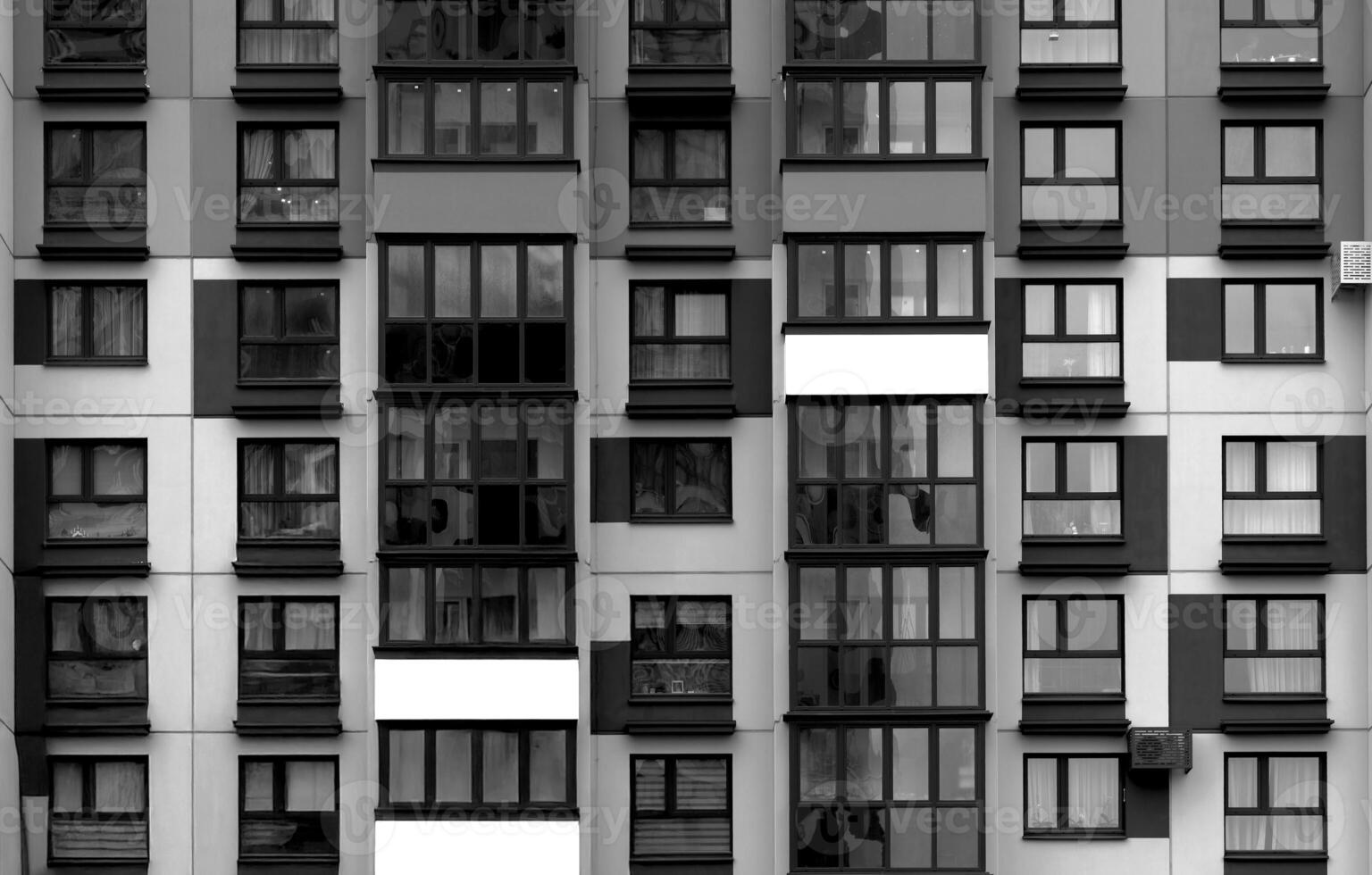 Building with black and white facade featuring windows and balconies in repeating geometric pattern. photo