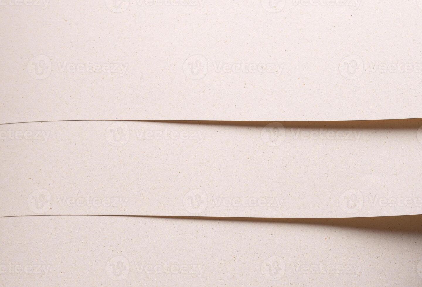 Close up of designer paper in beige and cream tones with porous speckled texture and organic fiber. photo