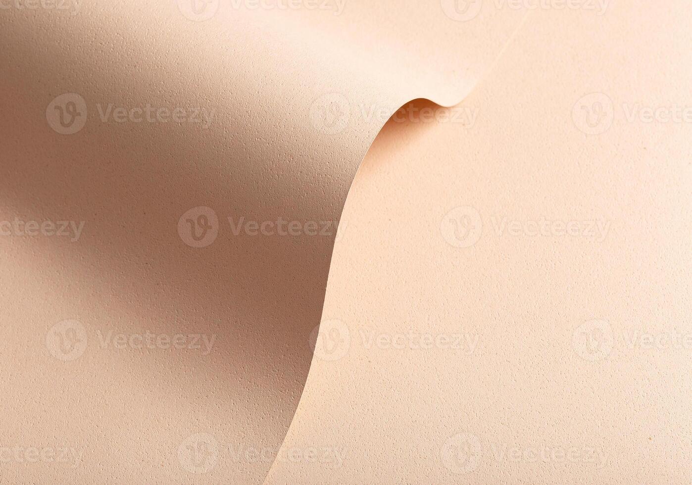 Monochrome background with wavy beige and cream designer paper. Curved folds and perforated shapes, photo