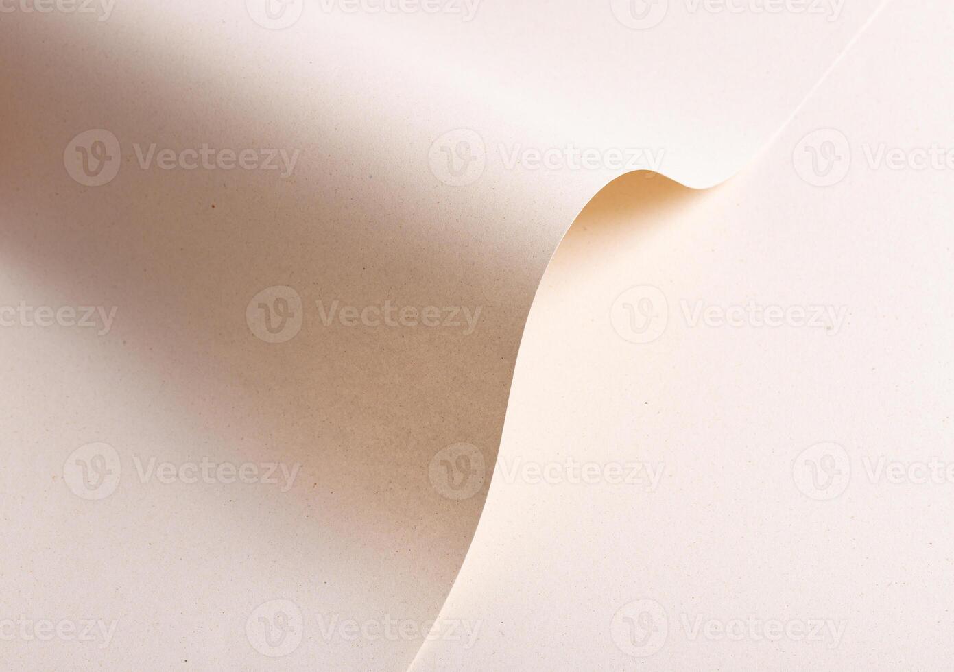 Elegant designer paper in creamy beige tones with folded and wavy shape. Natural recycled material photo