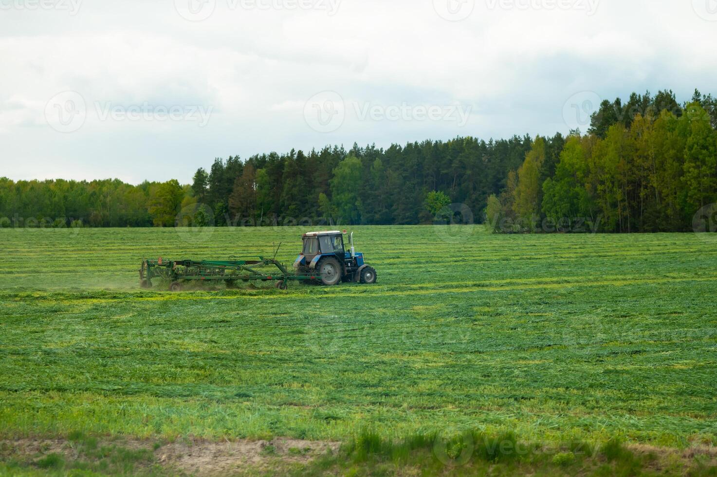 A tractor is working in a large field photo