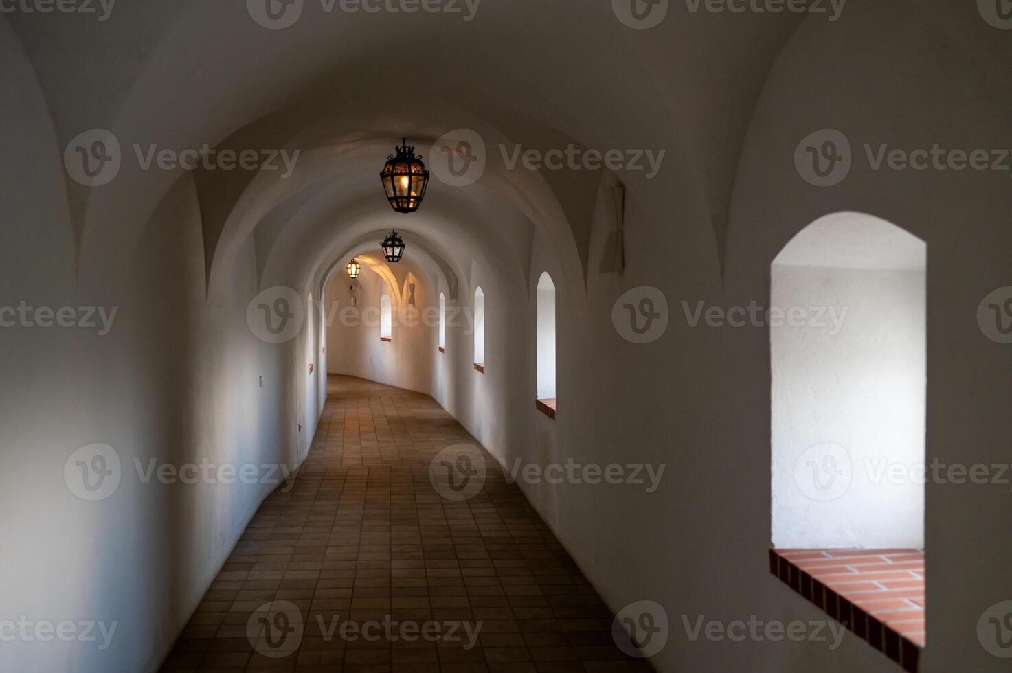 A long hallway with arched windows and a light photo