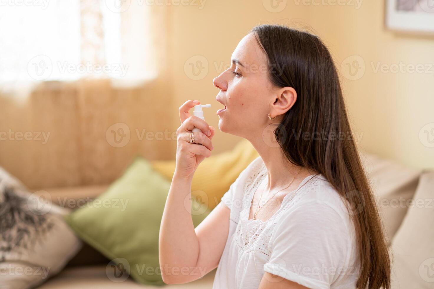 A woman is blowing her nose while sitting on a couch photo