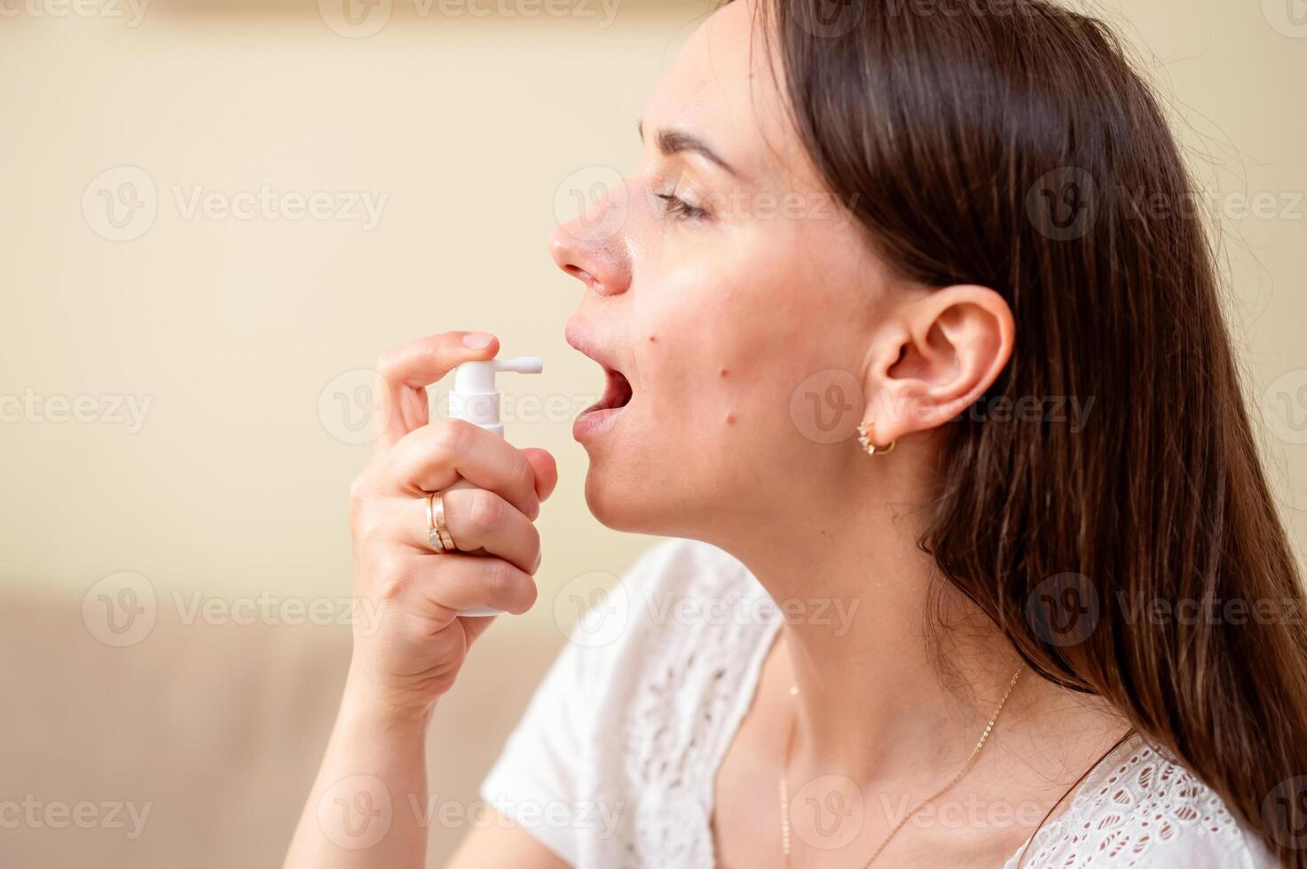 A woman is blowing her nose with an inhaler photo