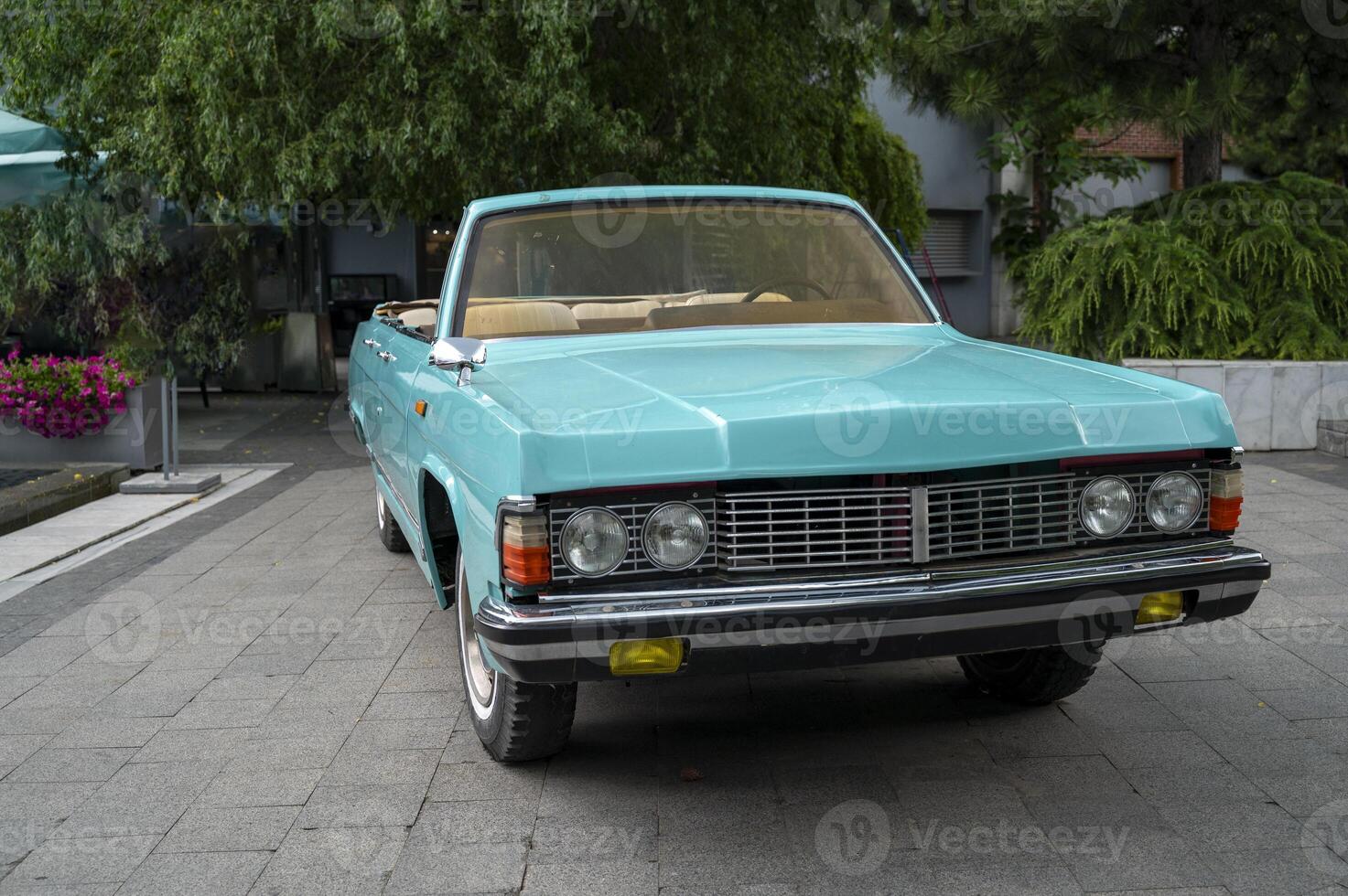 Vintage convertible, turquoise color and beige seats. stands on the street, Front view of a vintage turquoise open convertible. concept of bright summer and relaxation photo