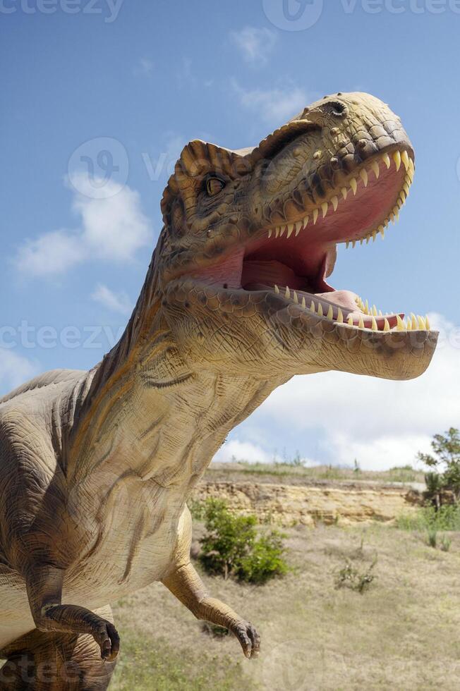 A fake dinosaur with its mouth open photo